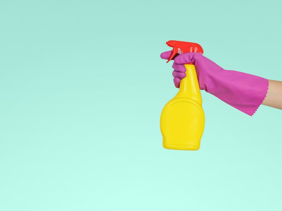 Gloved hand holding a cleaning spray bottle