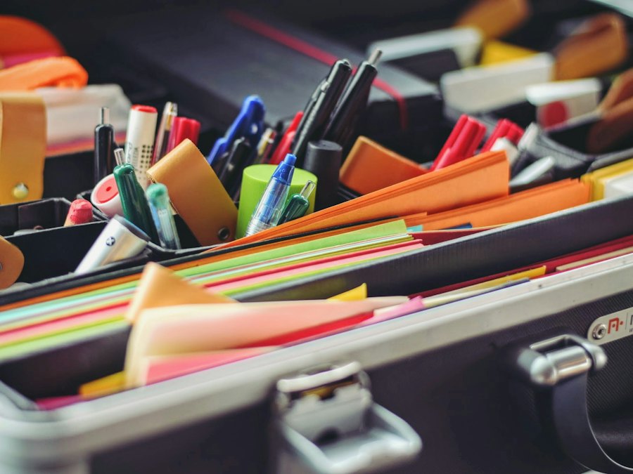 Pens, markers and sticky notes arranged in an office supplies case